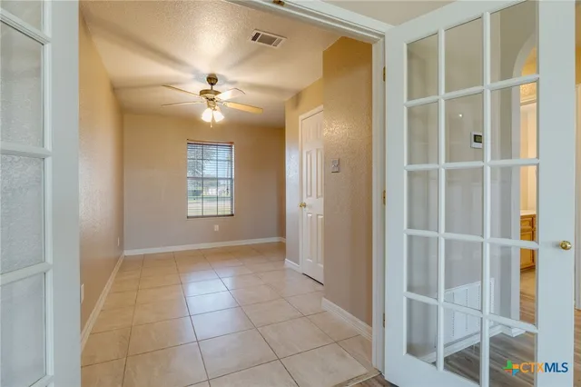 a view of an empty room with closet and a window