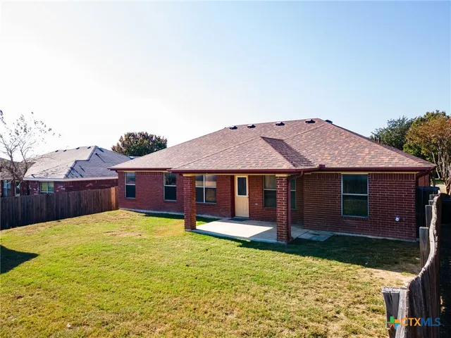 a view of a small house with wooden fence