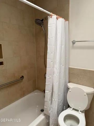 a bathroom with a toilet and a shower