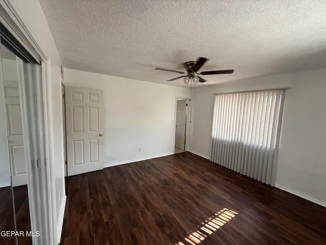 a view of a livingroom with wooden floor and a ceiling fan
