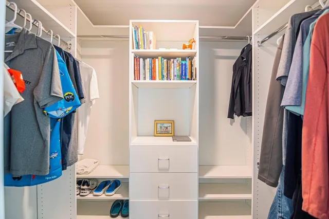 a view of walk in closet with clothes and shoes