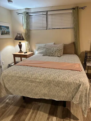 a bedroom with a bed and wooden floor