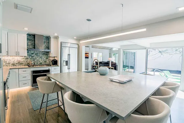 a kitchen with granite countertop a table chairs stove and kitchen island