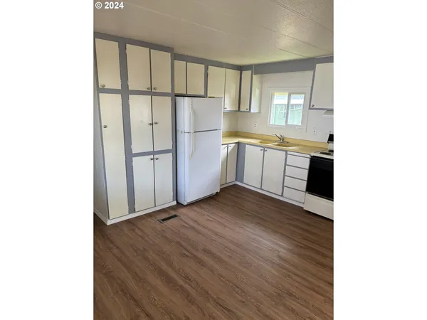 a kitchen with a refrigerator and white cabinets