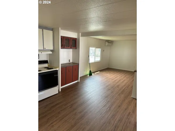 a view of a kitchen with wooden floor and electronic appliances