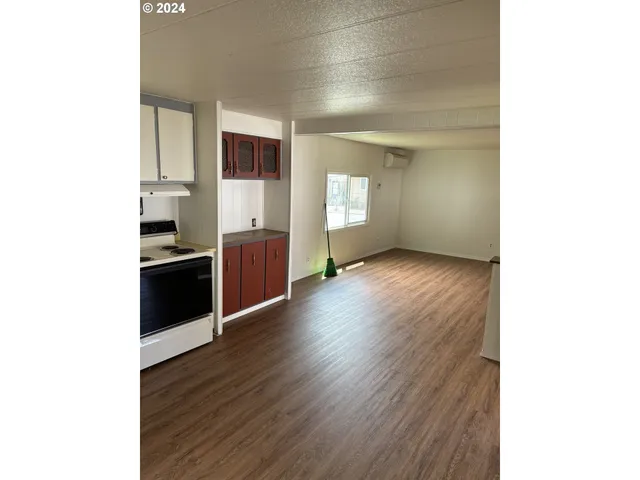 a view of a kitchen with wooden floor and electronic appliances