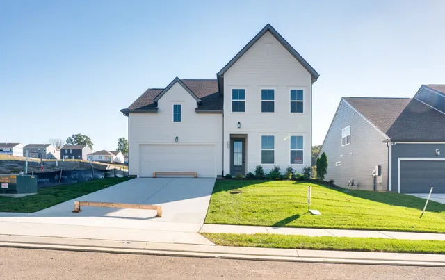 a view of a white house next to a yard