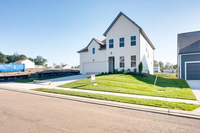 a view of a white house with a yard and large windows