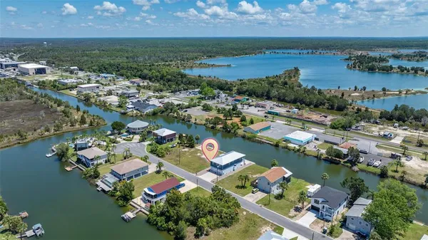 an aerial view of ocean and residential houses with outdoor space