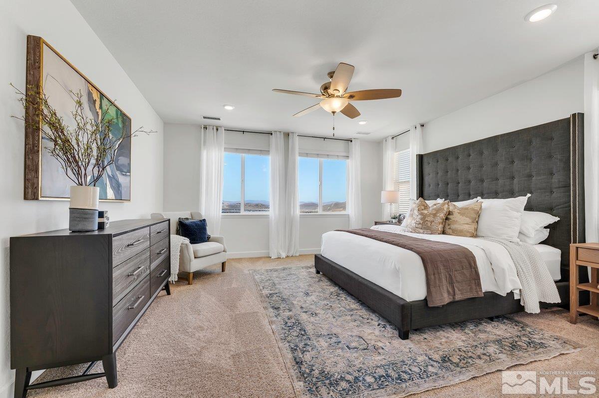 10537 Claim Jumper Way Reno, NV 89521 - Photo 19 of 40 a spacious bedroom with a bed a couch and a large window