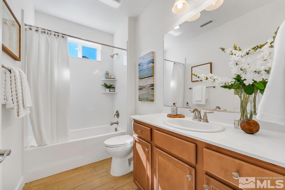 10537 Claim Jumper Way Reno, NV 89521 - Photo 23 of 40 a bathroom with a granite countertop sink a toilet and shower