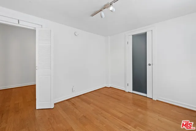 a view of empty room with wooden floor