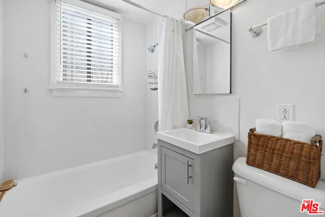 a bathroom with a sink toilet vanity and bathtub