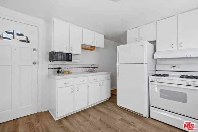 a kitchen with cabinets stainless steel appliances and wooden floor