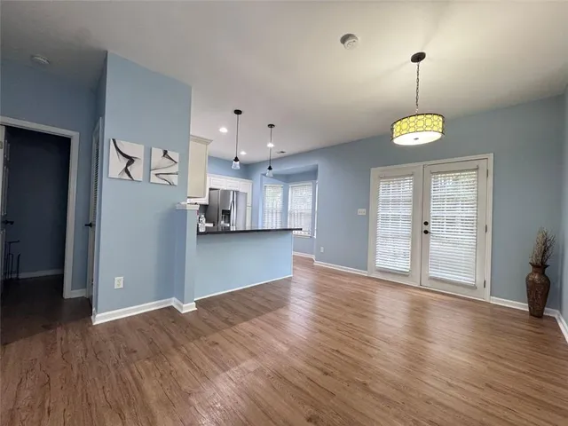 a view of empty room with wooden floor and window