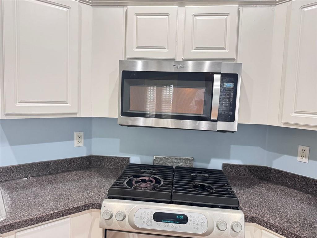 5495 Hampton Court Atlanta, GA 30349 - Photo 17 of 20 a kitchen with granite countertop white cabinets and stainless steel appliances