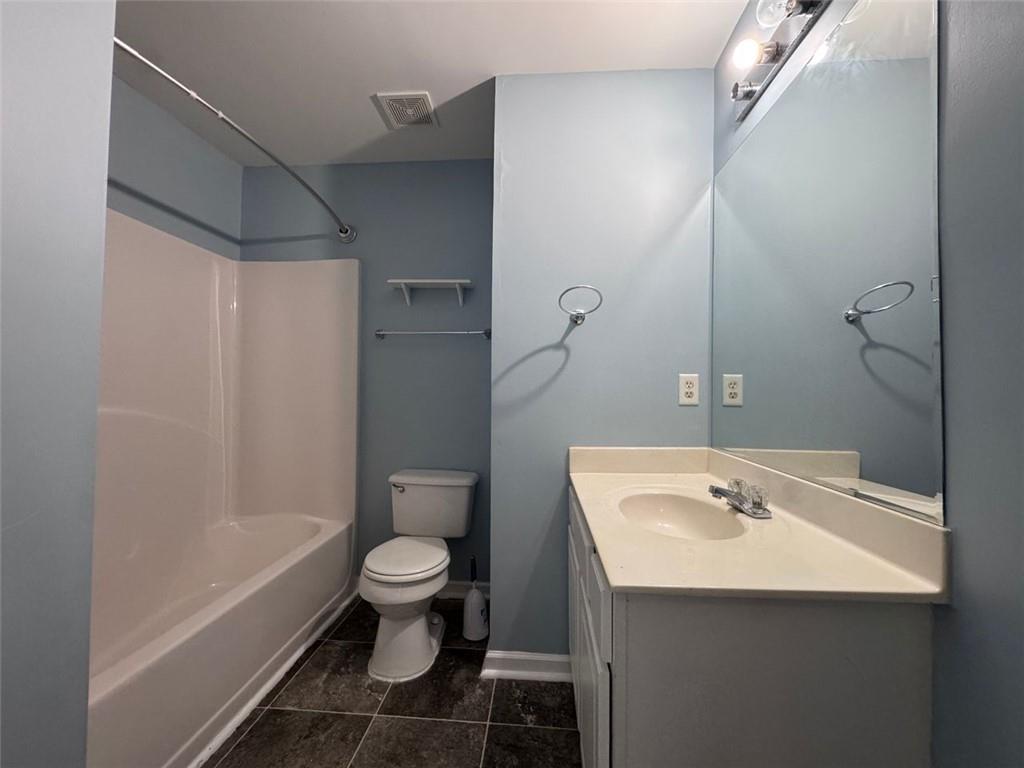 5495 Hampton Court Atlanta, GA 30349 - Photo 4 of 20 a bathroom with a sink a toilet and shower