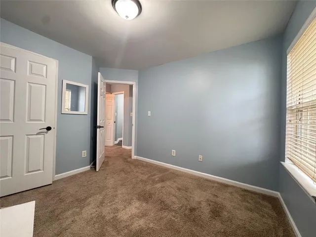 an empty room with windows and closet