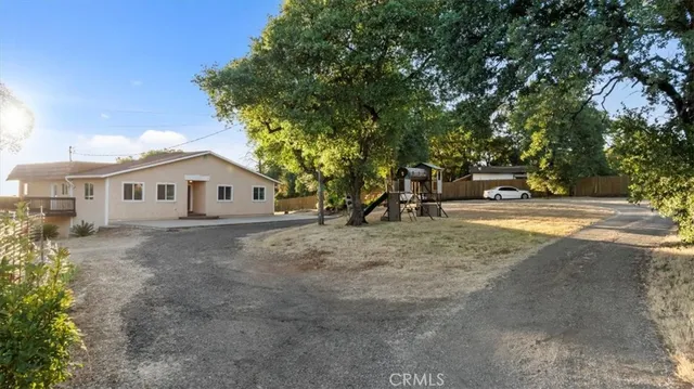 a view of a house with backyard and a tree