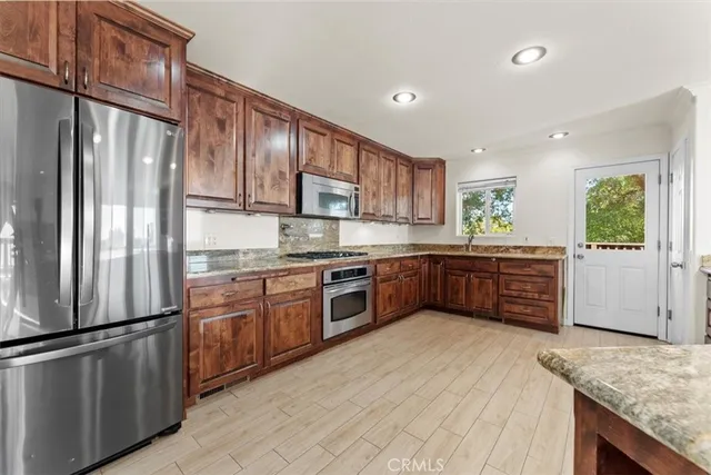 a kitchen with granite countertop stainless steel appliances a sink and a window