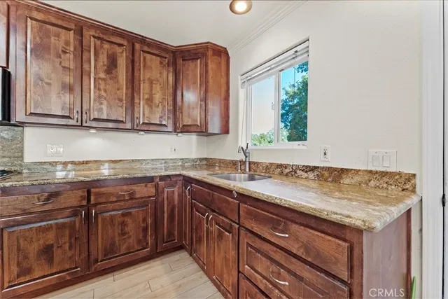 a bathroom with a sink toilet a mirror and next to a window