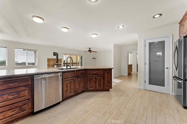 a large kitchen with stainless steel appliances granite countertop a large counter top a sink and a refrigerator
