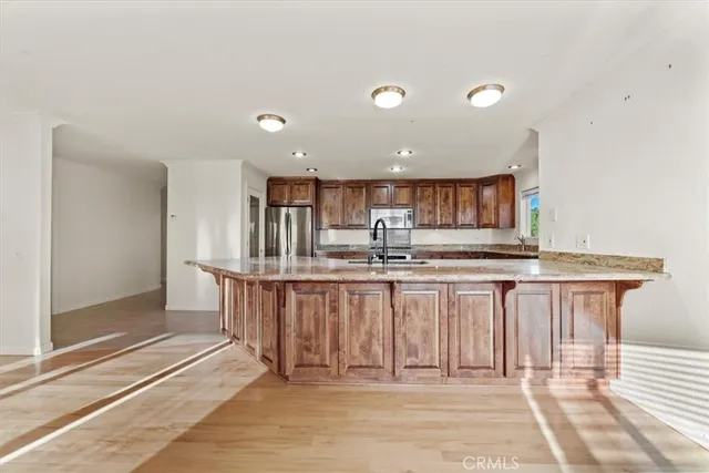 a kitchen with kitchen island granite countertop a sink and cabinets