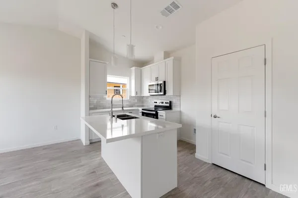 a kitchen with cabinets and wooden floor