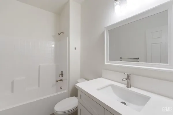 a bathroom with a sink toilet vanity and shower