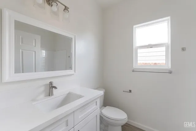 a bathroom with a sink a toilet and a window