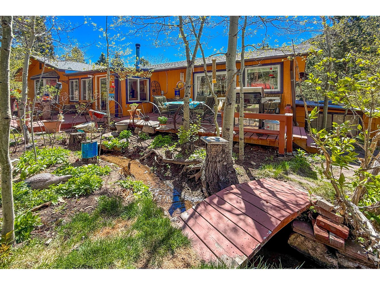 2508 Riverside Drive Lyons, CO 80540 - Photo 5 of 50 a view of a patio with table and chairs potted plants and large tree