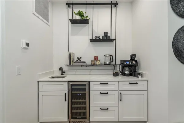 a kitchen with white cabinets and sink