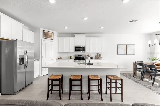 a kitchen with a sink a stove cabinets and a wooden floor