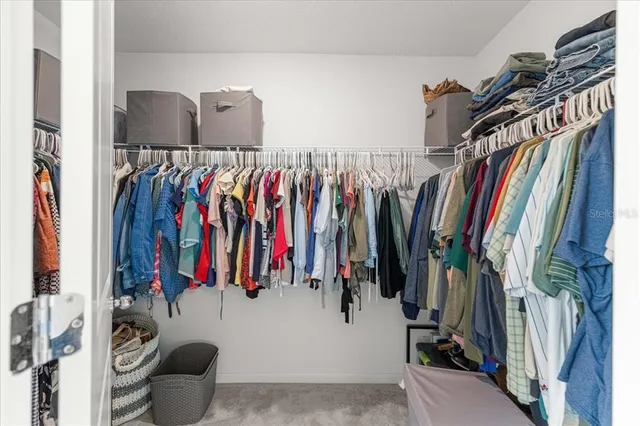 a view of a hallway with closet and a bathroom
