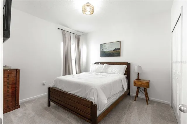 a bedroom with a bed table and a potted plant