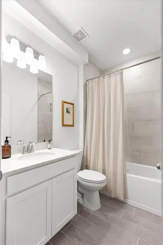 a white toilet and tub sitting next to a bathroom sink