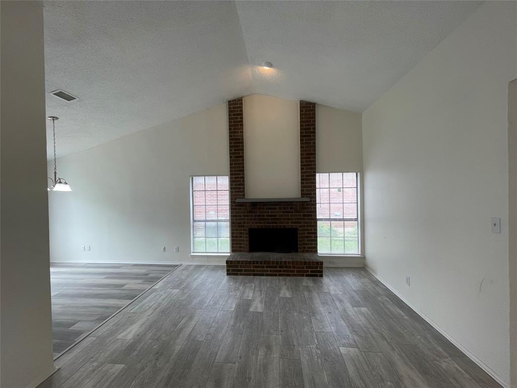 9415 Rutherglen Drive Dallas, TX 75227 - Photo 4 of 18 a view of empty room with wooden floor and fireplace