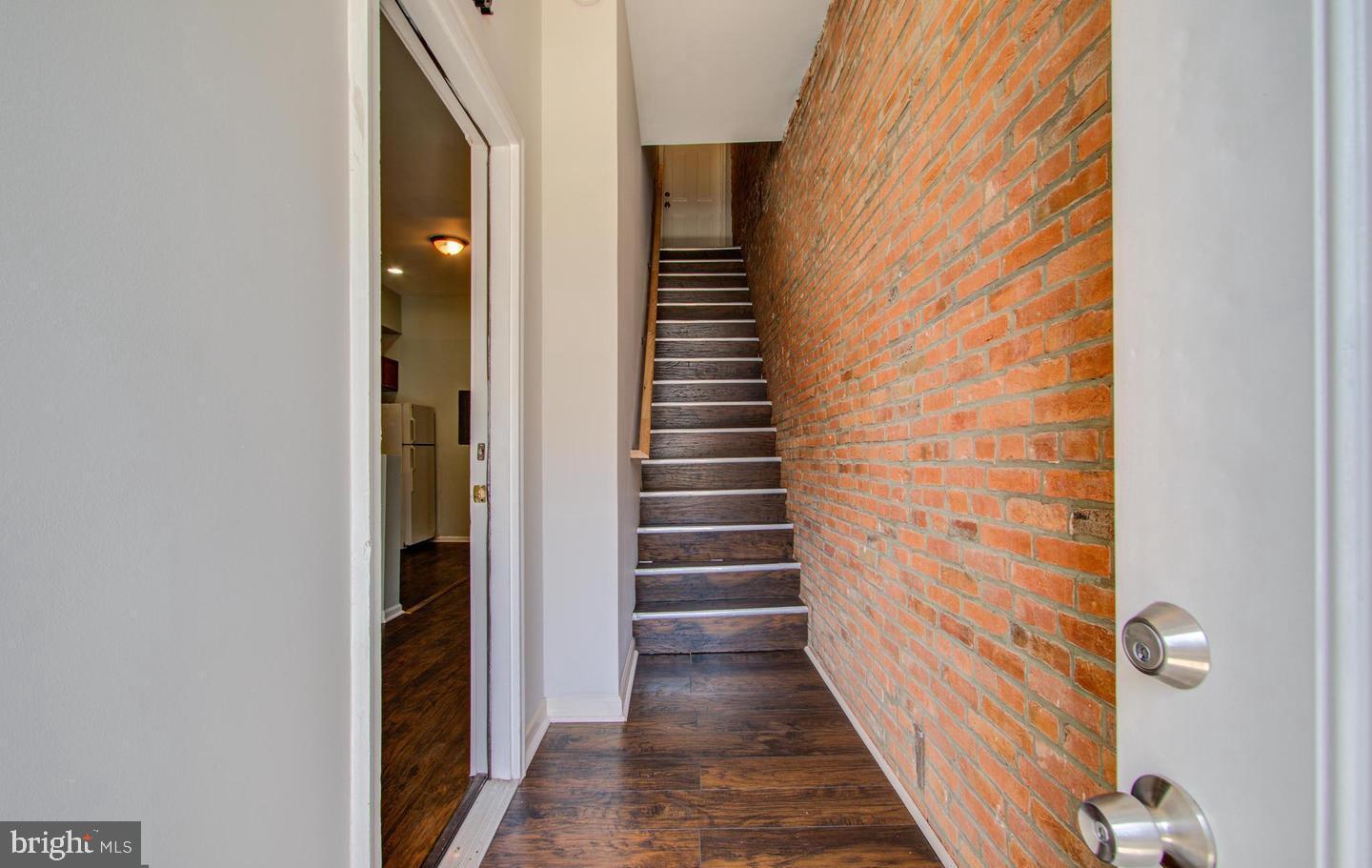 a view of a hallway with stairs and wooden floor