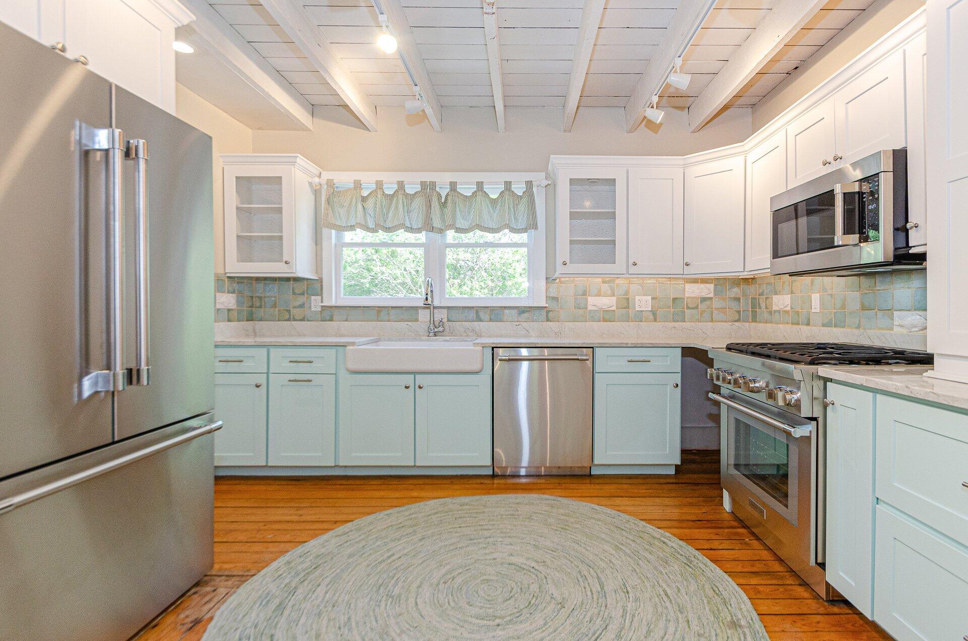 1089 Main Street Cotuit, MA 02635 - Photo 11 of 41 a kitchen with stainless steel appliances granite countertop a sink stove and refrigerator