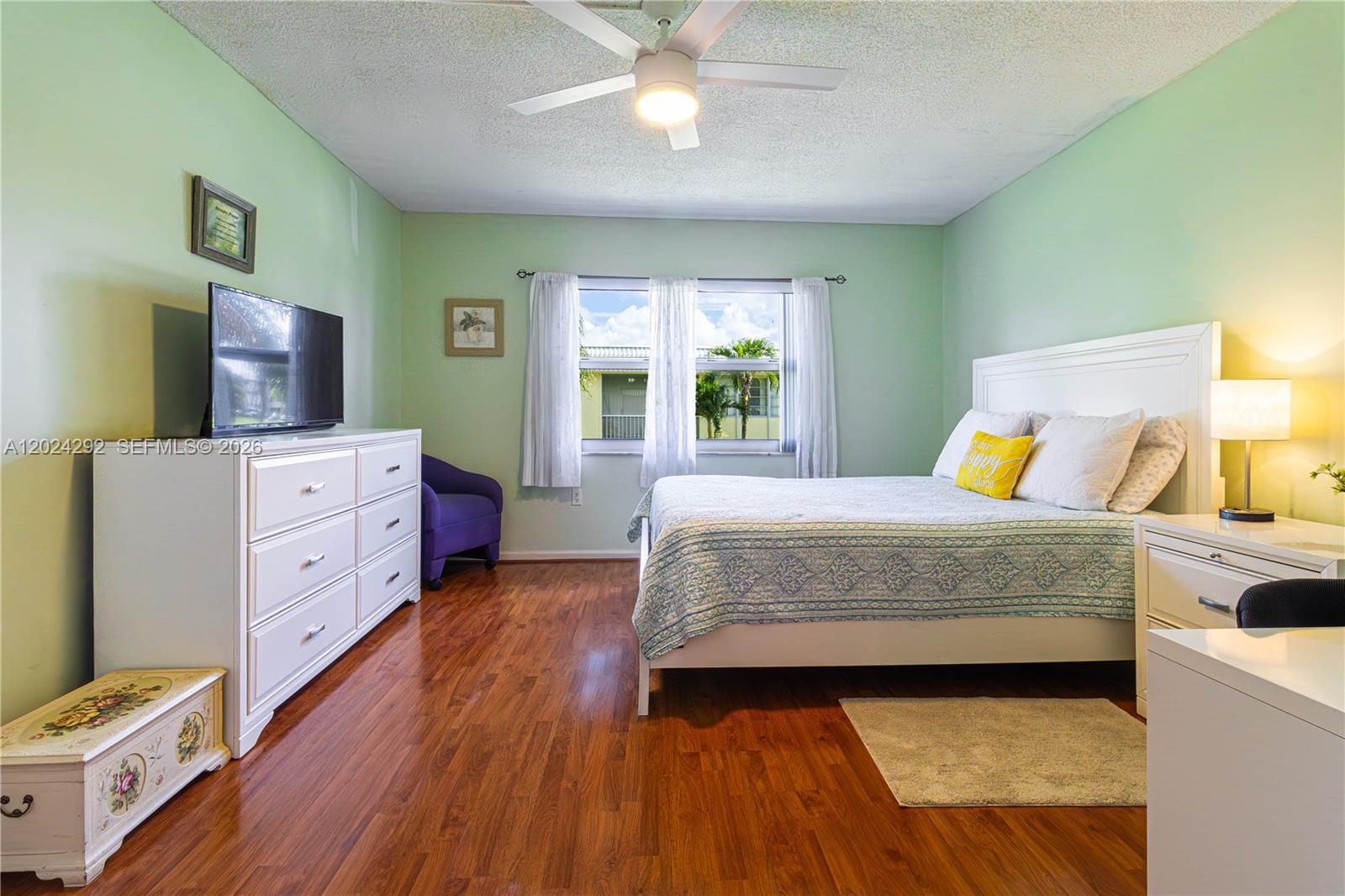 9780 Marina Boulevard, Unit 424 Boca Raton, FL 33428 - Photo 21 of 32 a bedroom with a bed and wooden floor