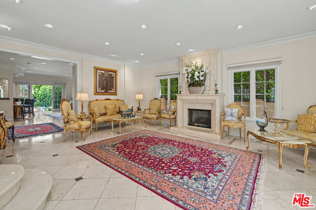 204 Foothill Road Beverly Hills, CA 90210 - Photo 7 of 38 a living room with furniture a rug and a fireplace