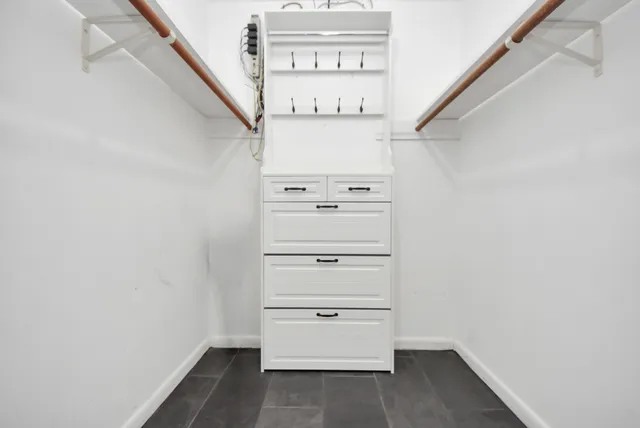 a view of walk in closet with empty racks