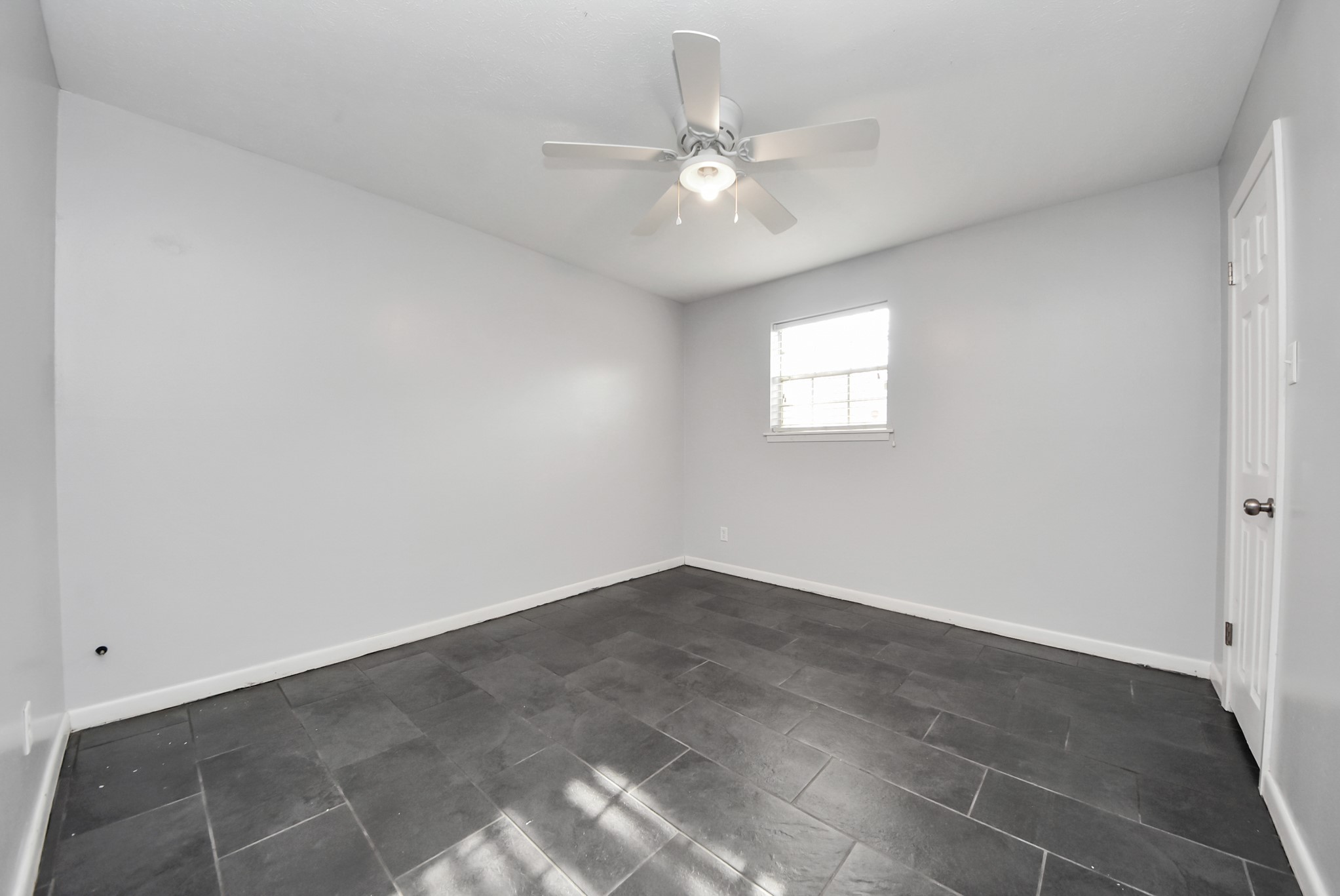2004 Manor Street Dayton, TX 77535 - Photo 17 of 21 an empty room with windows and fan