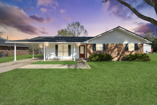 a view of a house with a yard and a garden