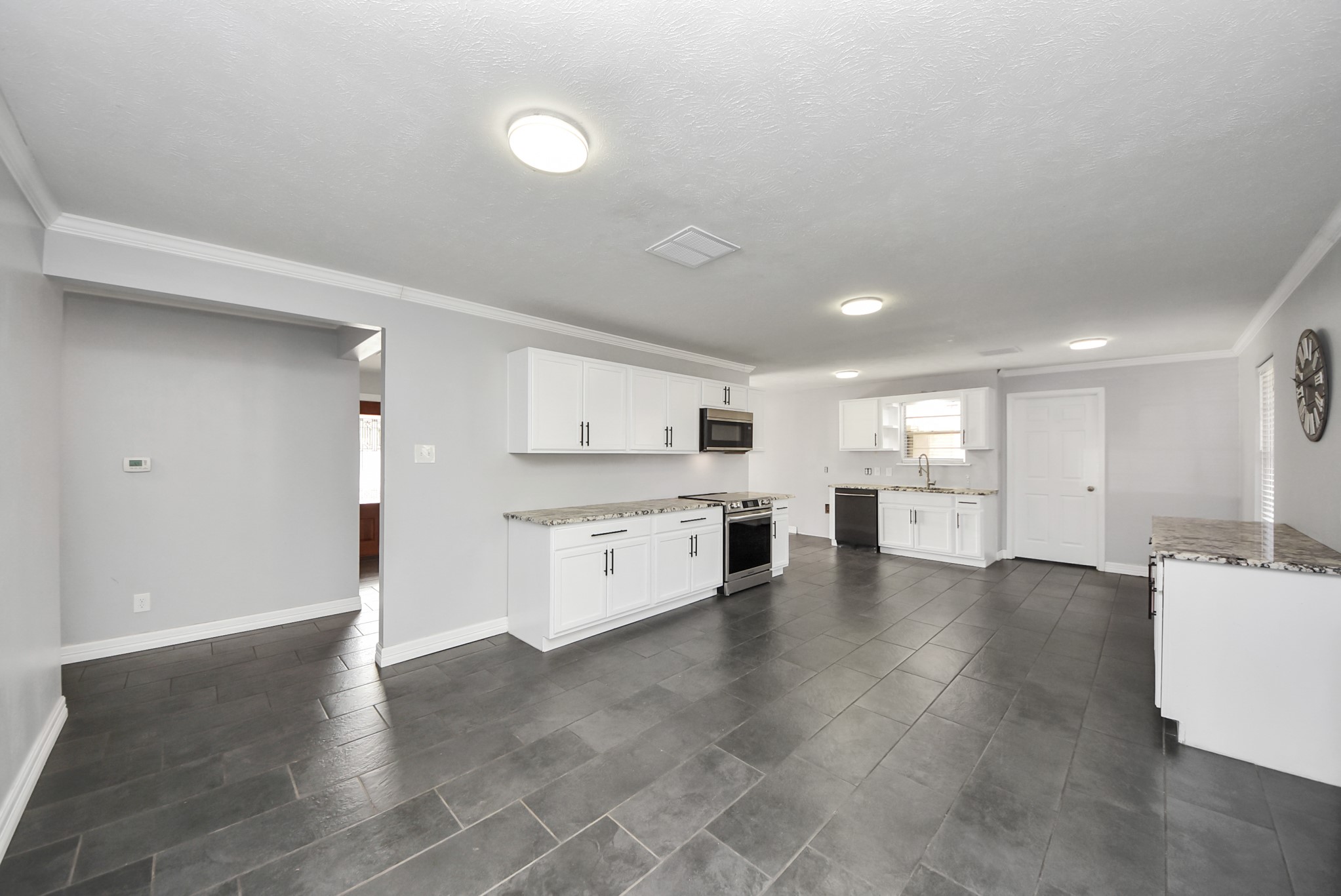 2004 Manor Street Dayton, TX 77535 - Photo 8 of 21 a large white kitchen with a stove a sink dishwasher and a refrigerator with wooden floor