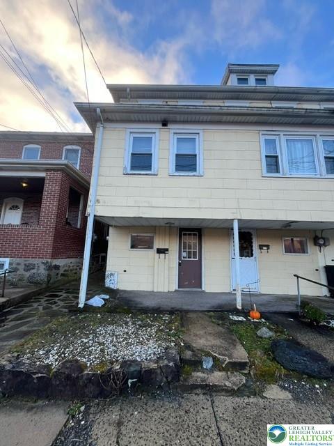 135 West Ridge Street Nesquehoning, PA 18240 - Photo 1 of 6 Multi-level residential exterior showcasing private entryways and classic multi-pane windows.