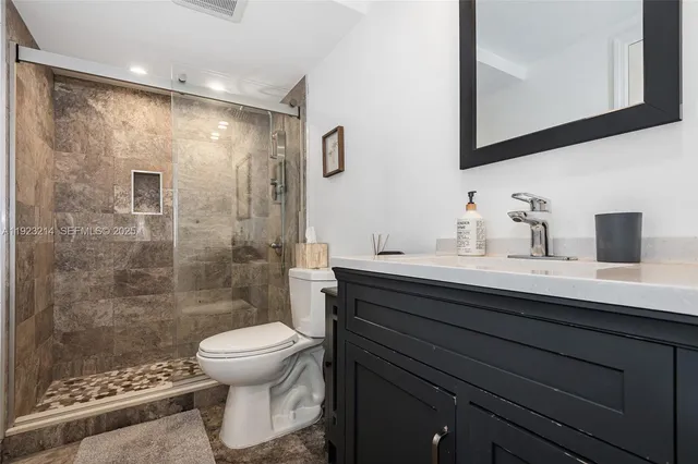 a bathroom with a sink a toilet and shower