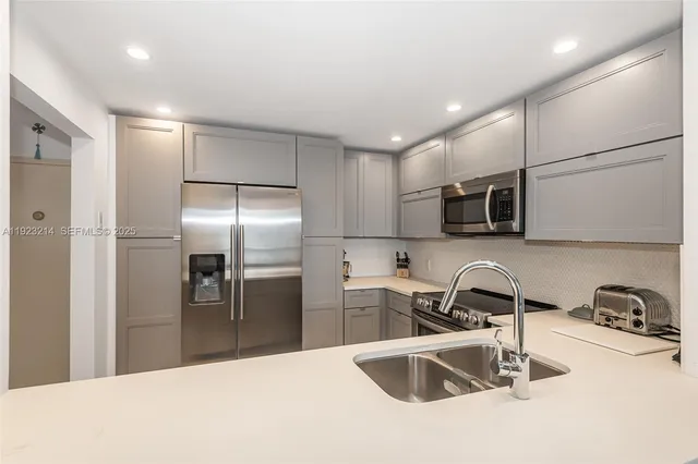 a kitchen with stainless steel appliances granite countertop a sink and a refrigerator