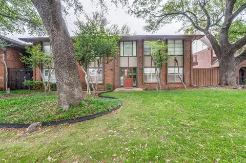 a view of a house with a yard and tree s