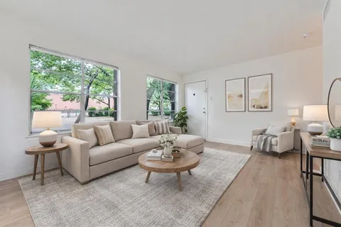 a living room with furniture a table and a large window